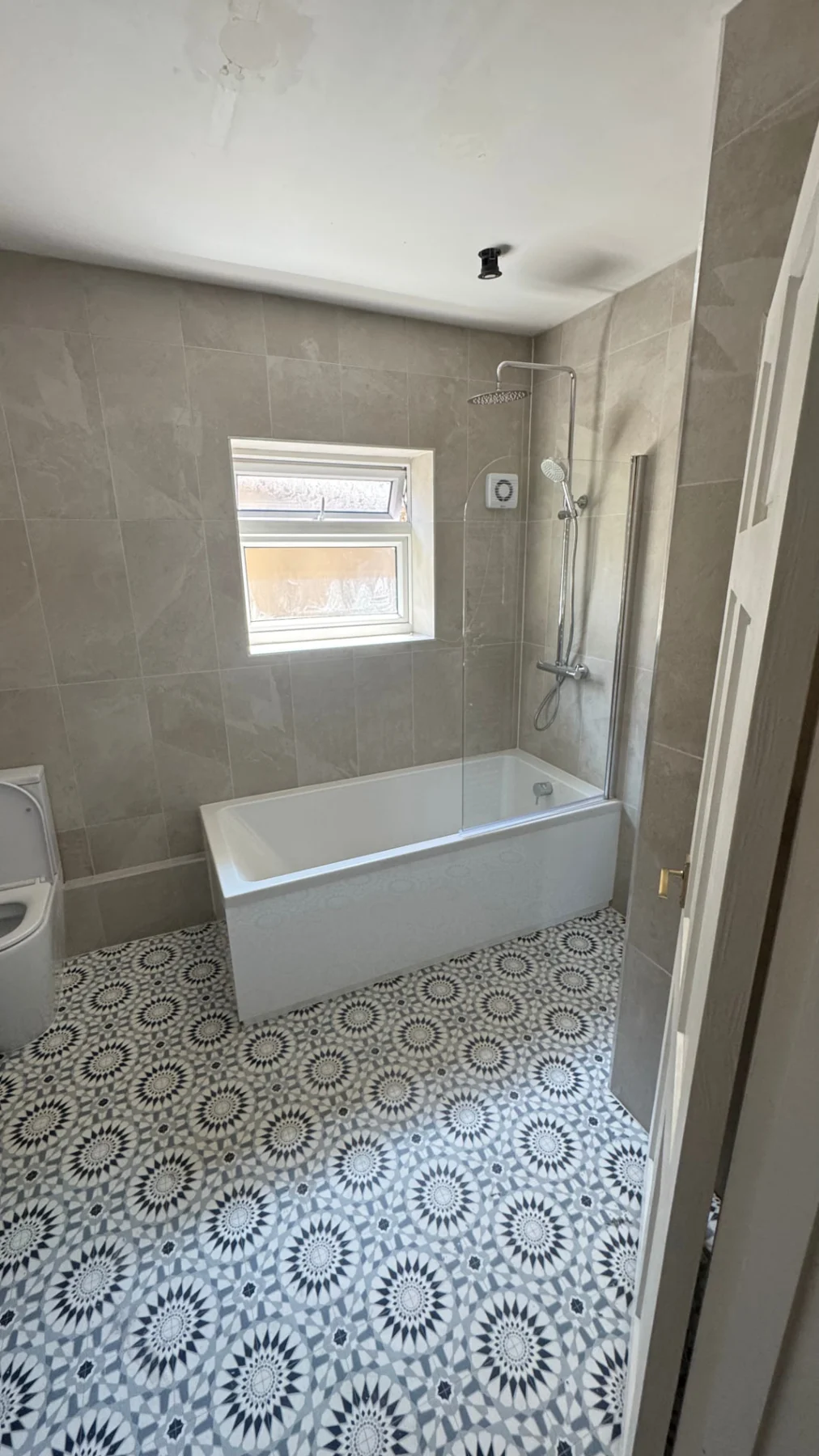 Bathroom with a freestanding bath and patterned floor tiles