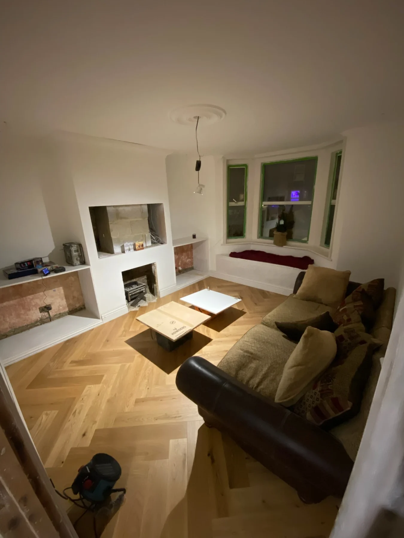 Renovated living room with built-in fireplace and herringbone floor