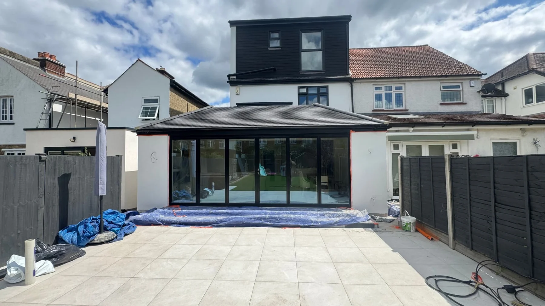 Rear house extension with dark-framed glazed doors and a tiled roof