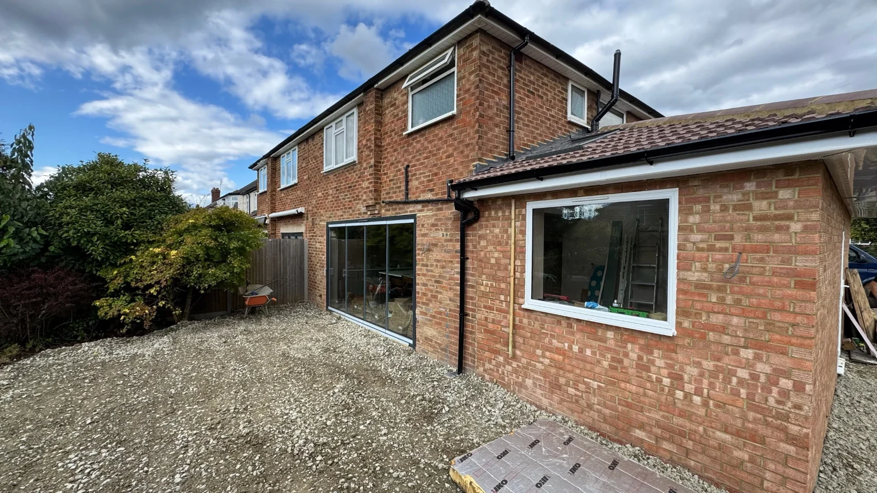 Brick house extension with window openings and gravel garden ground